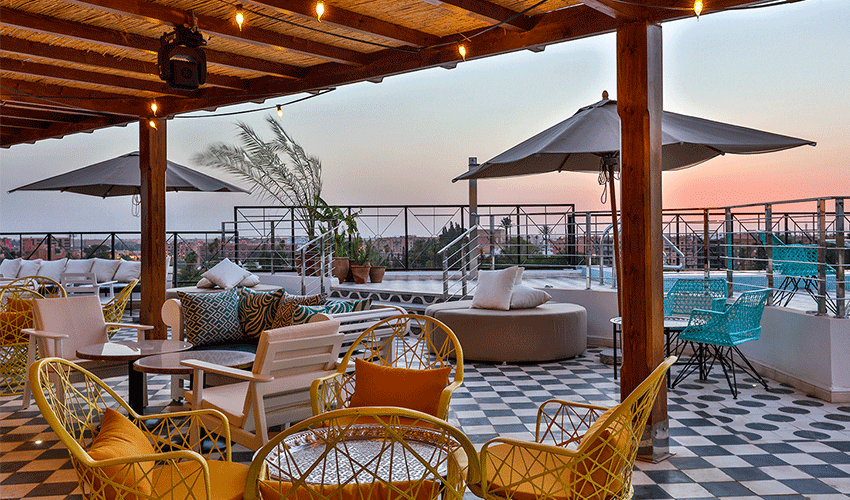 Out Adventures' Marrakesh hotel terrace. The floor is checkered and the furniture is mismatched.